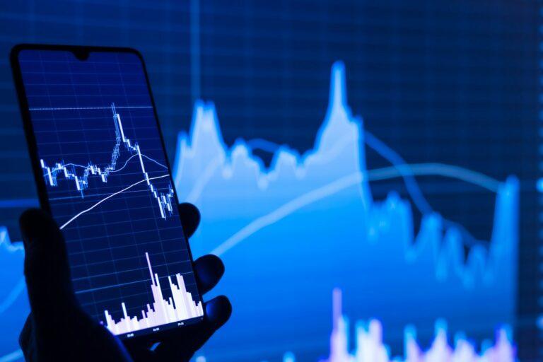 Palantir Stock Investors Find Relief: Growth Surges, Doubts Wane a person holding a cell phone in front of a stock chart